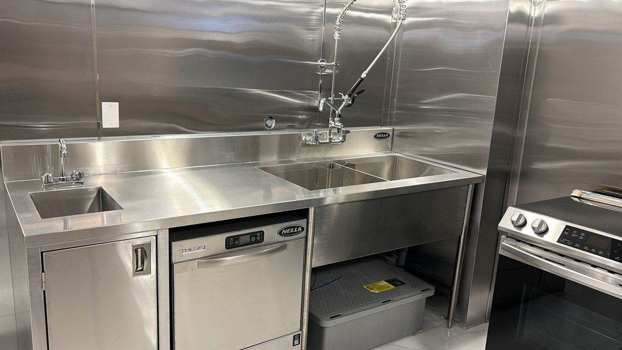 A kitchen with a sink , dishwasher , and stove.