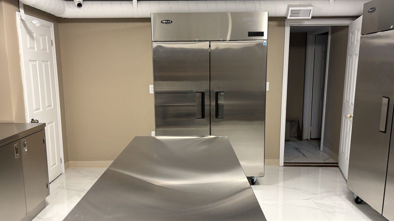 A kitchen with stainless steel appliances and a stainless steel table.