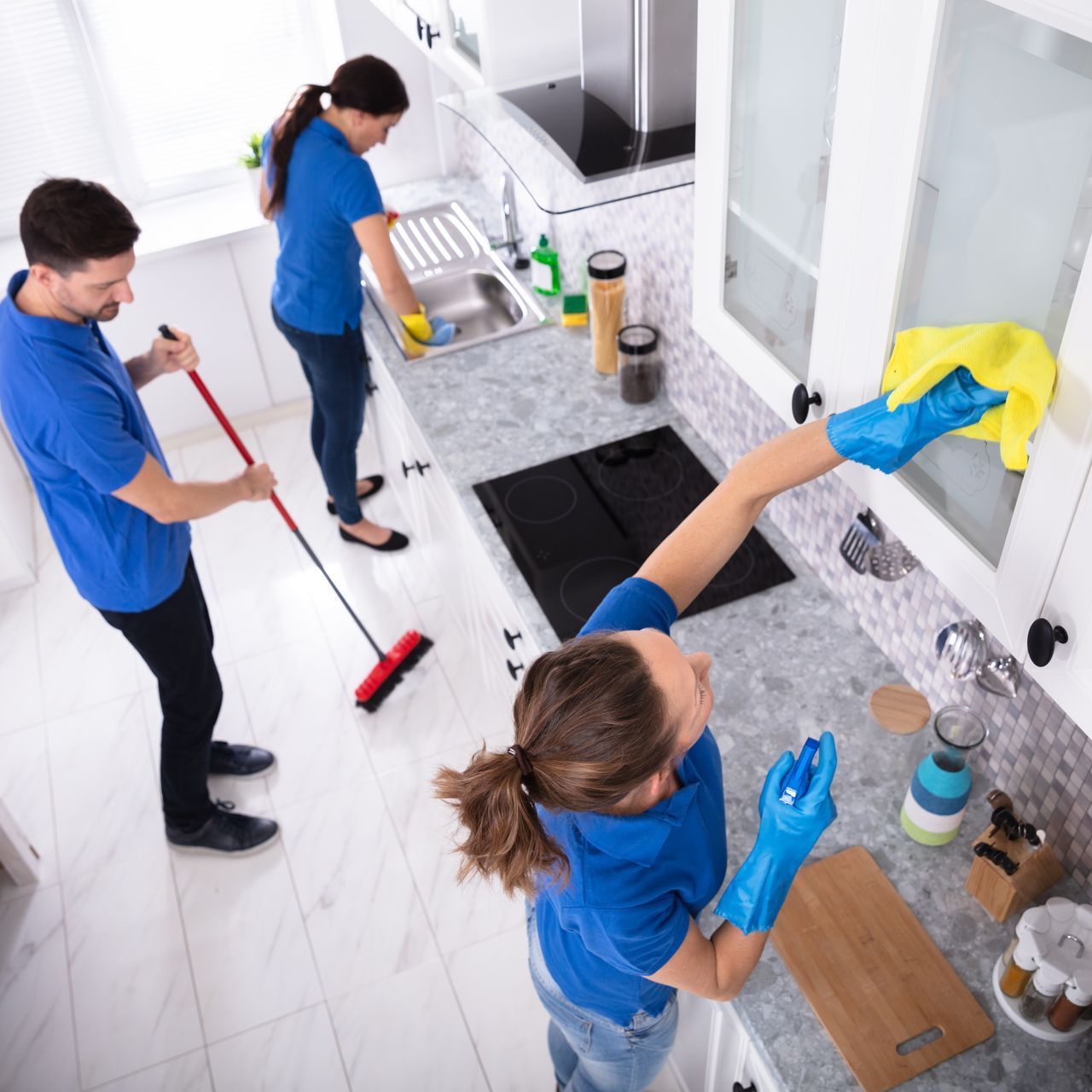 a group of people are cleaning a kitchen together .