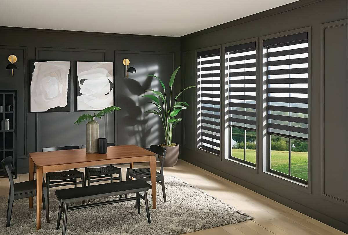 Modern dining room with wooden table, black chairs, dark walls, and large windows with striped blinds.