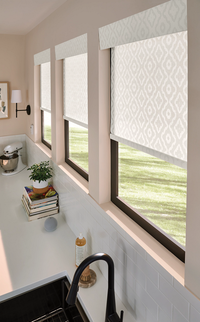 White plantation shutters filtering bright daylight beside a sheer floral curtain