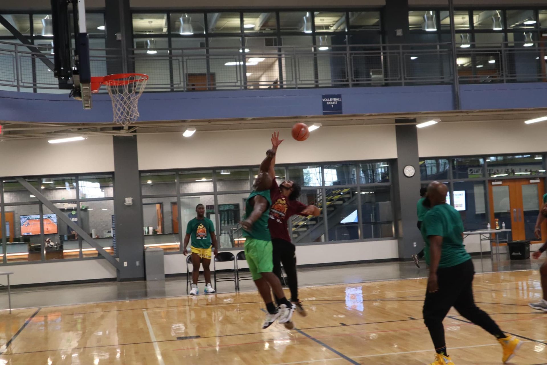 A group of people are playing basketball on a court.