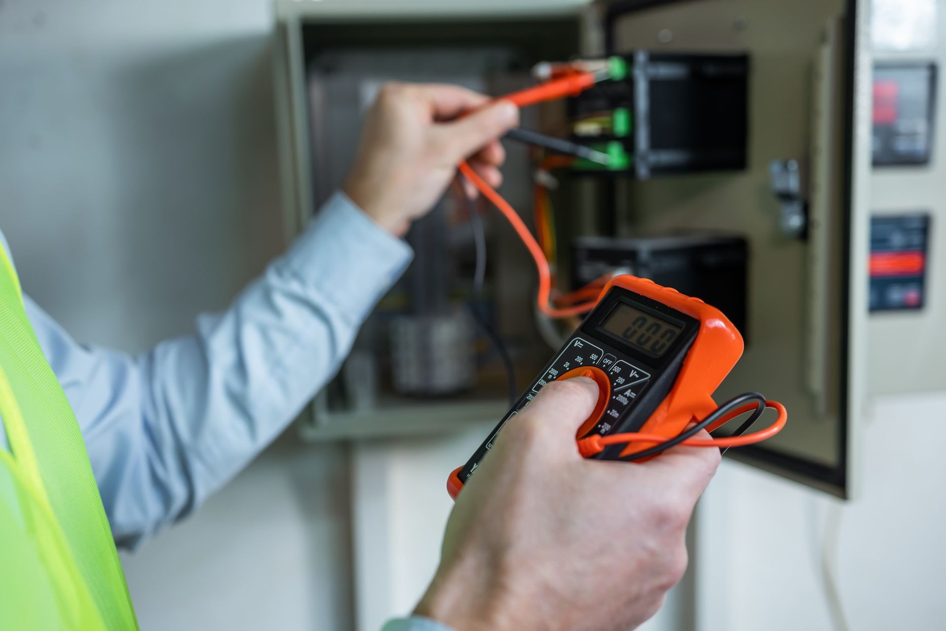 A technician performing electrical troubleshooting with an insulated screwdriver on a control panel. A technician performing electrical troubleshooting with an insulated screwdriver on a control panel.
