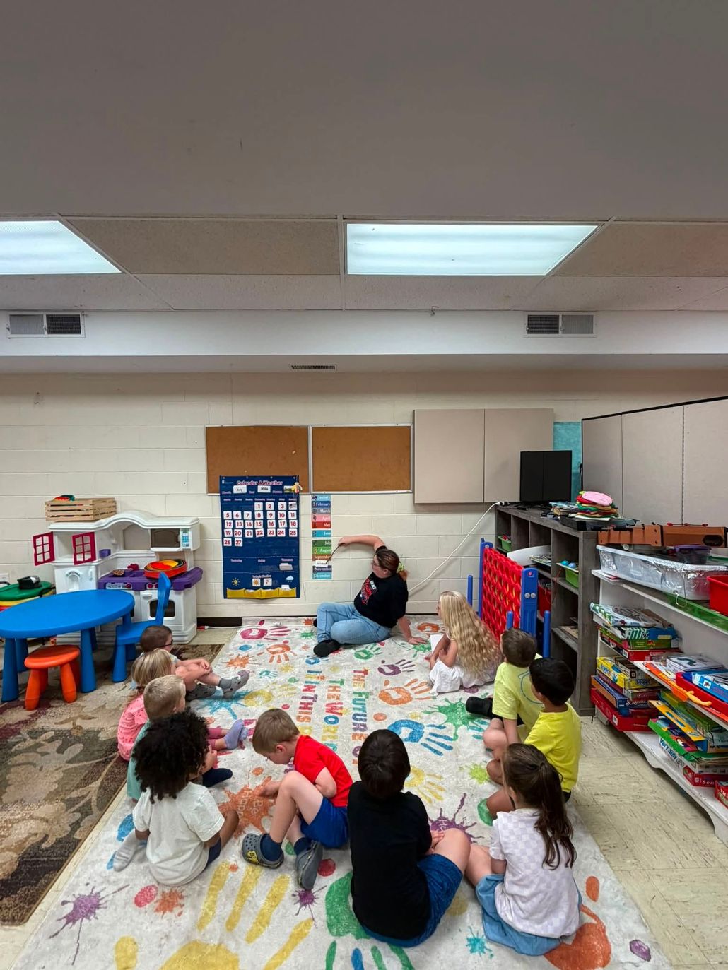 Children drawing on a light table with colored zigzag lines in a playroom