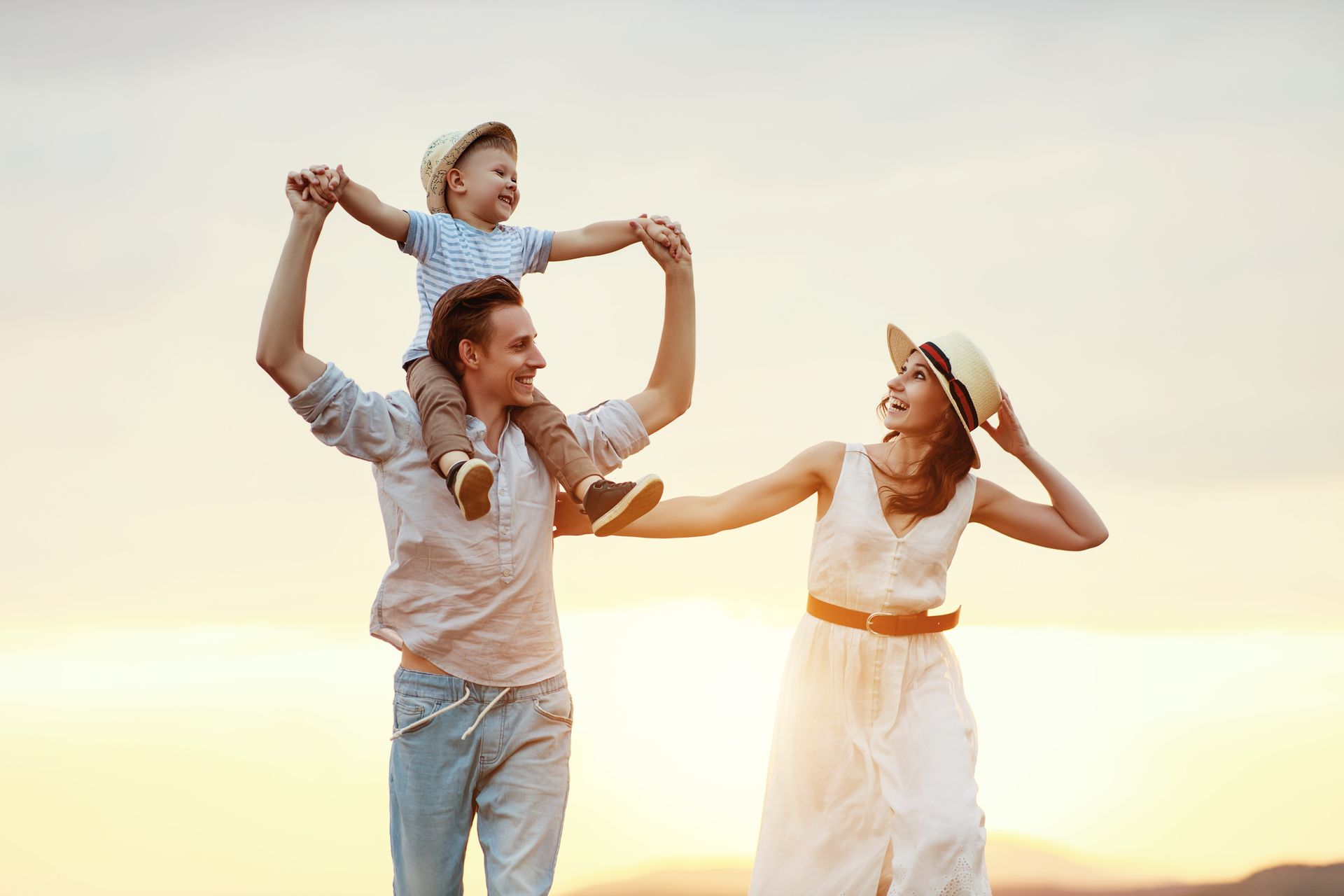 The young woman, her husband, and child take a hike during sunset - they have benefited from learning how to find a life coach