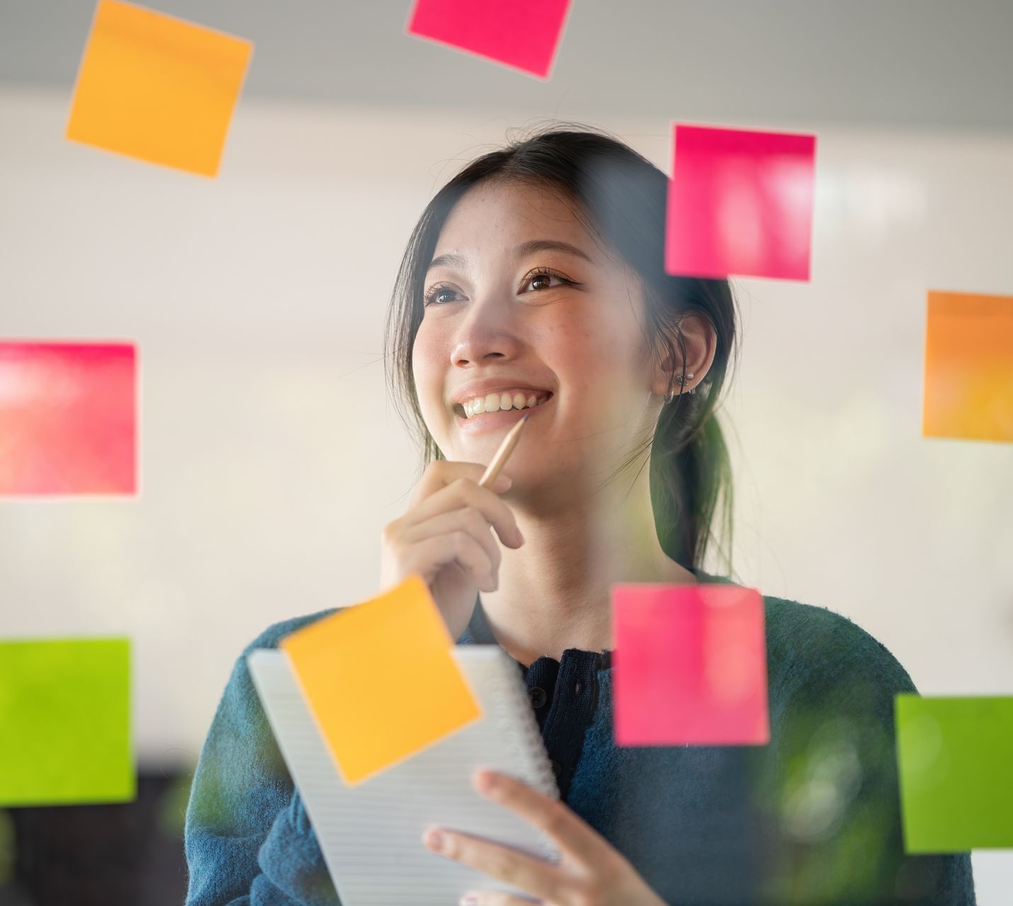 The same woman stands surrounded by sticky notes on a glass wall, conidering the differences between career coaching vs career counseling