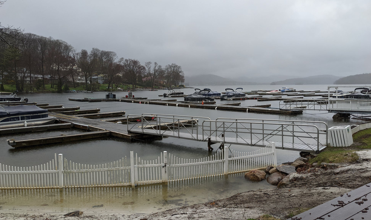 A lot of boats are docked at a marina on a cloudy day.