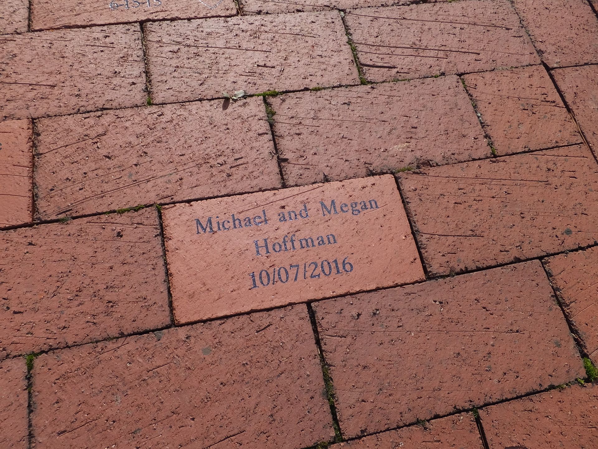 Brick pavement with a small engraved memorial plaque in the center.