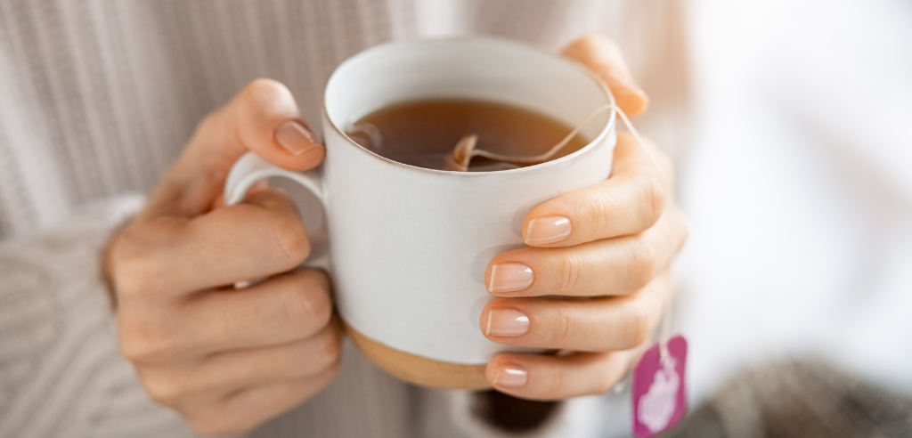 Woman holds mug of hot tea