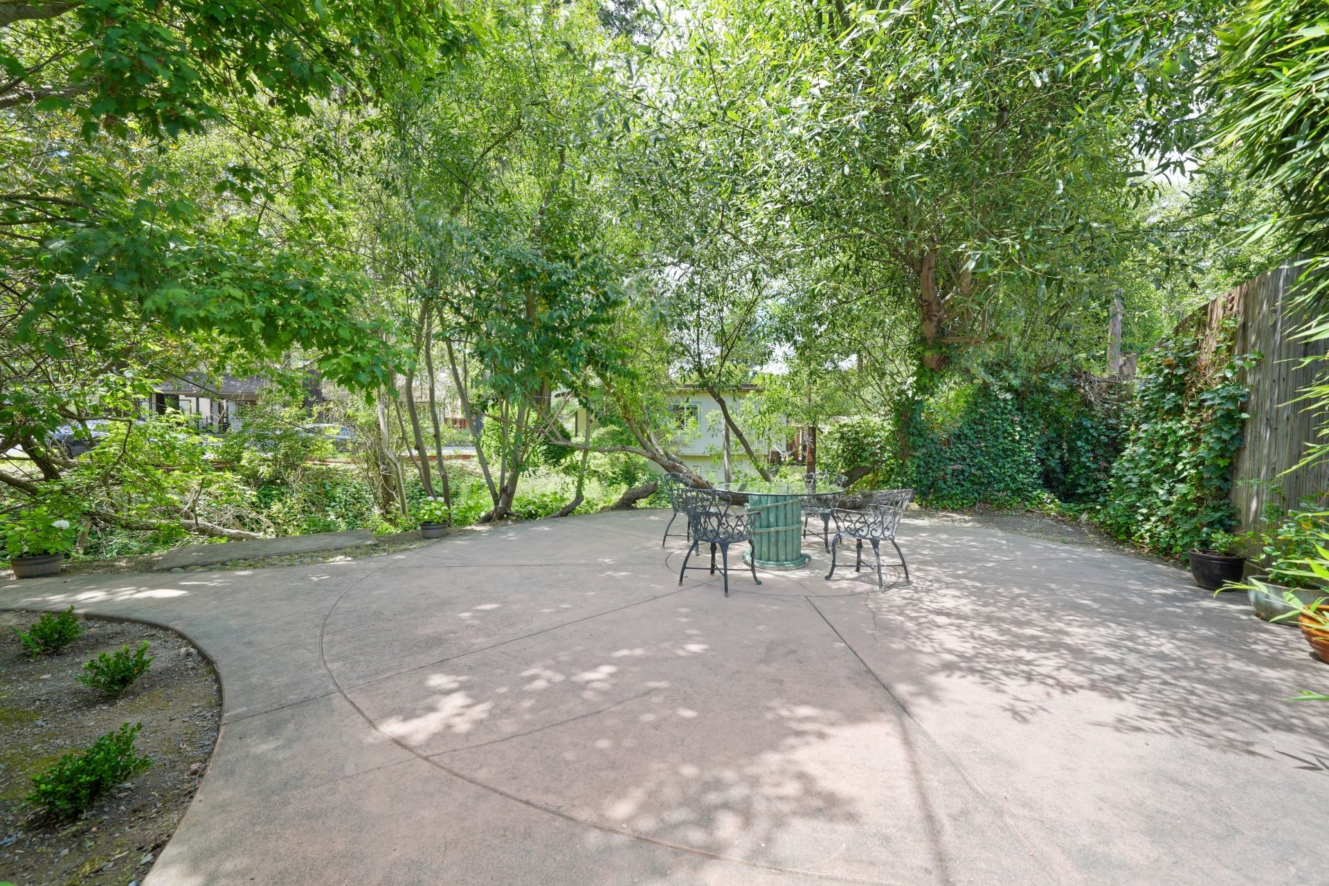 King Deluxe Suite Patio area with table, chairs, and surrounded in greenery