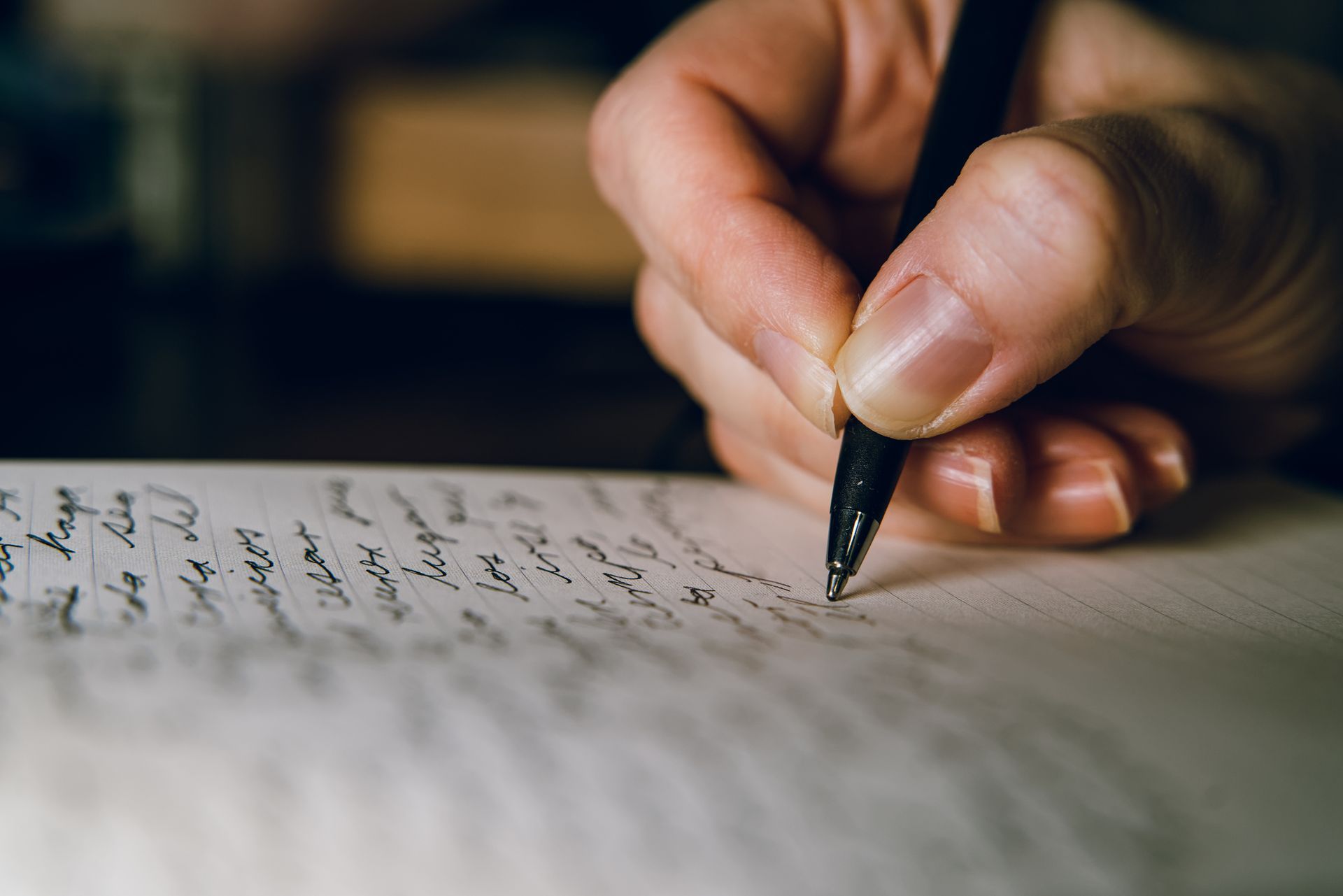 A person is writing on a piece of paper with a pen.
