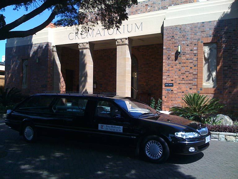 A black car is parked in front of a crematorium