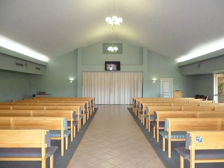 The inside of a church with rows of wooden benches