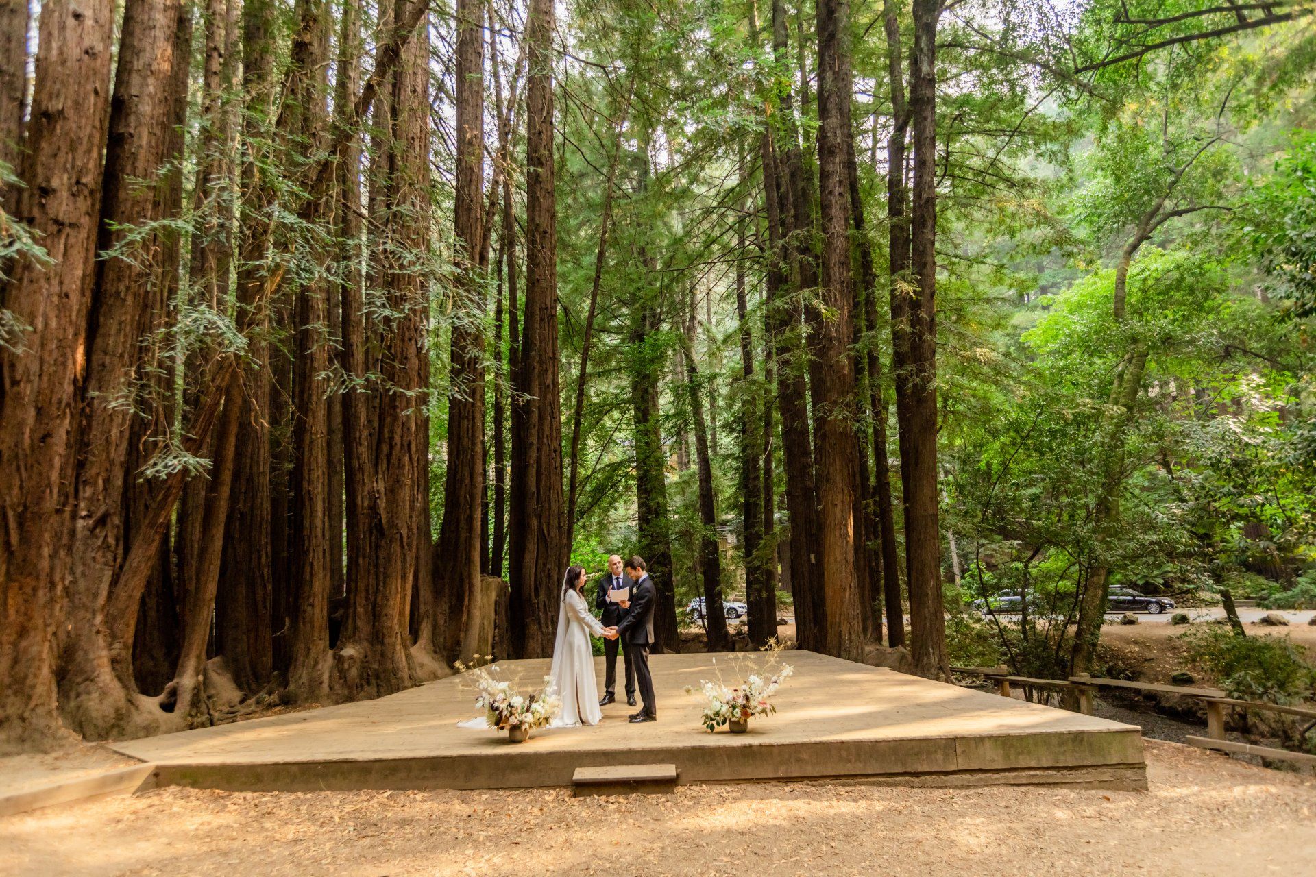 A bride and groom are getting married in the middle of a forest.
