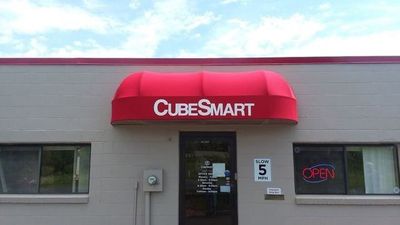 A store front with a red awning that says cubesmart