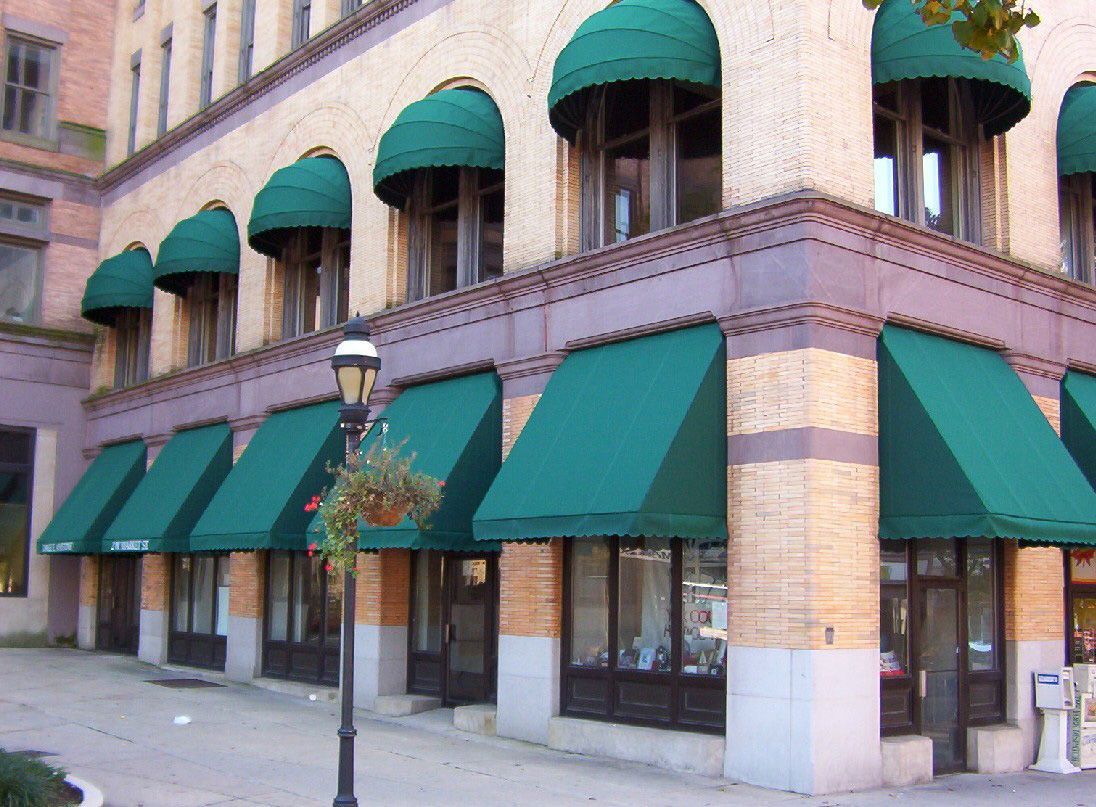 A building with green awnings on the windows