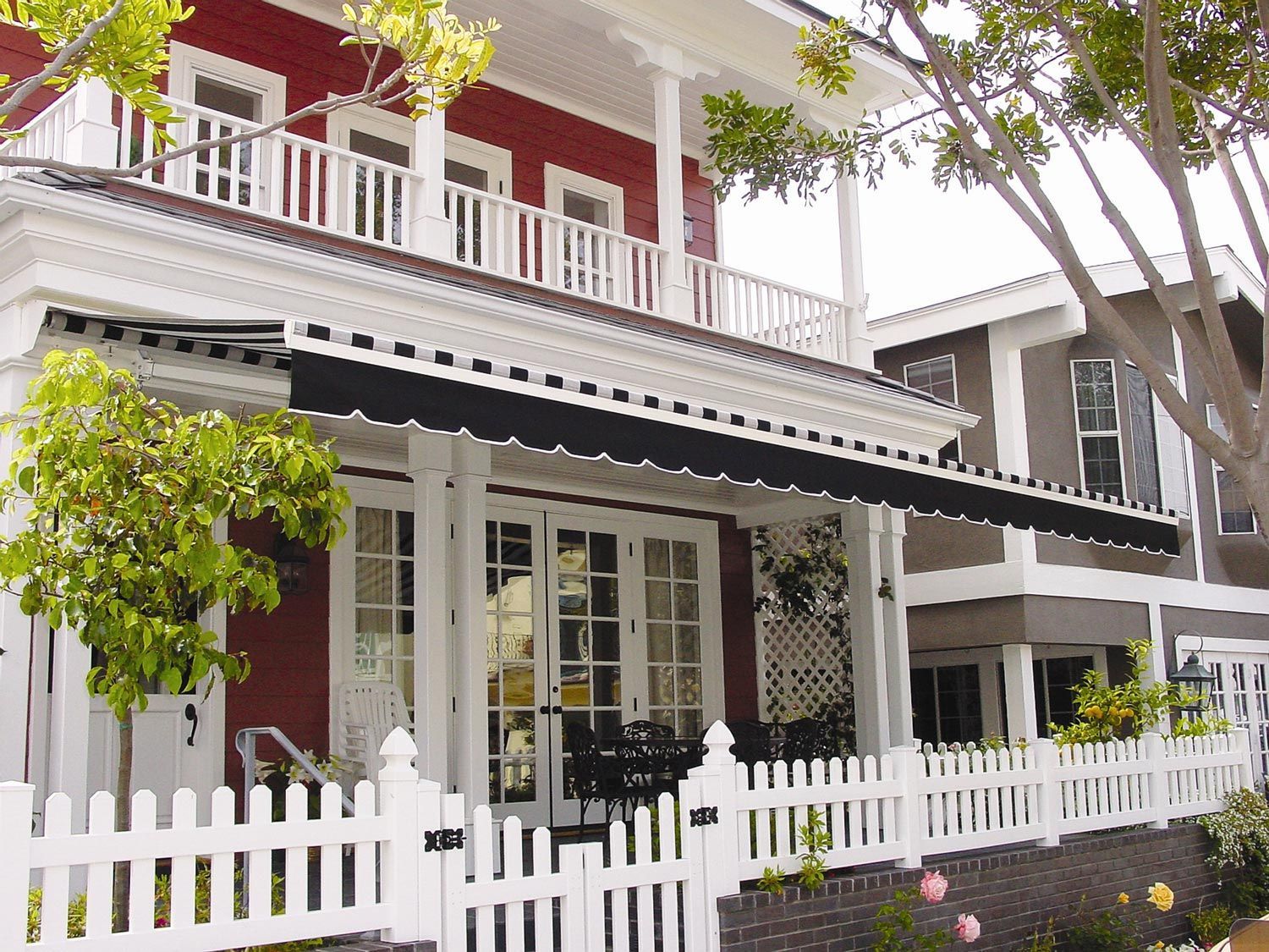A red house with a white picket fence around it