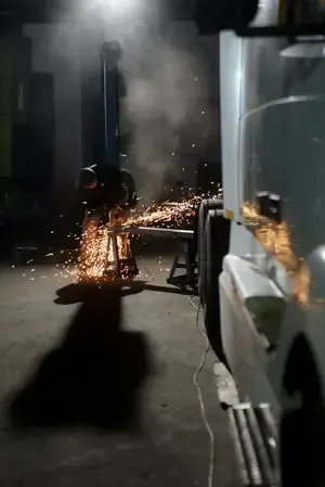 Fireworks spraying from a vehicle at night in a dark alley, with smoke and sparks visible