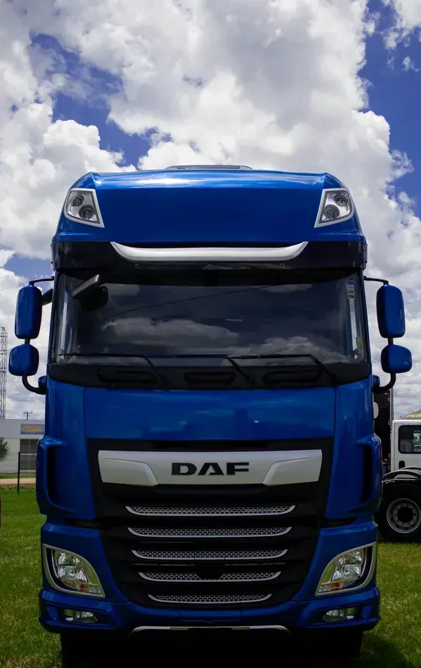 Blue DAF semi-truck front view against a cloudy sky