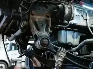 Close-up of a car engine with hoses, metal parts, and wiring visible under the hood