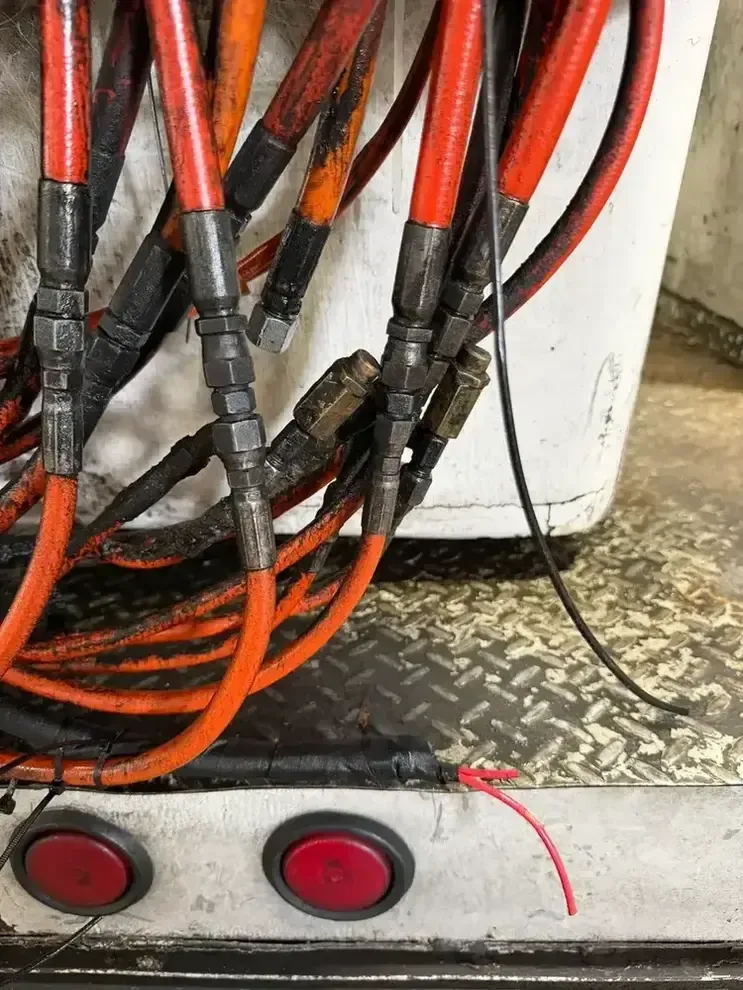 Close-up of two black cables with silver metal connectors and clamps.