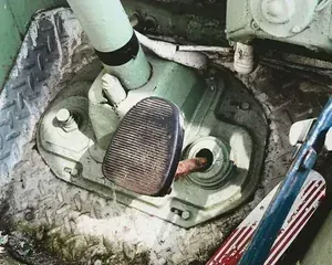 Close-up of a car’s manual gear shift and pedals inside the driver’s footwell.