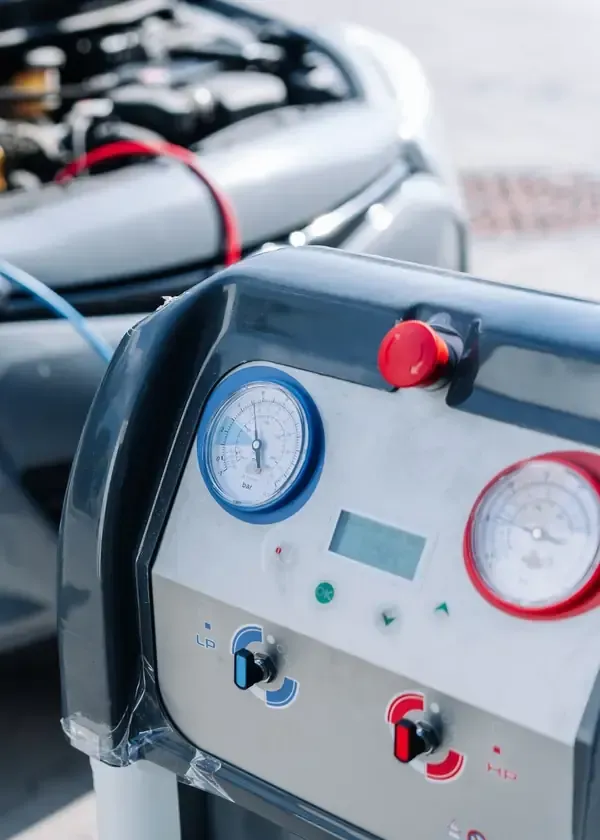 Close-up of a control panel with gauges, switches, and red emergency buttons on industrial equipment