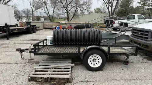 Underneath a semi-trailer, showing the landing gear and support frame on pavement.
