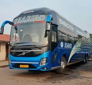 Blue Seabird coach bus parked on a wet lot, front angled toward the camera.