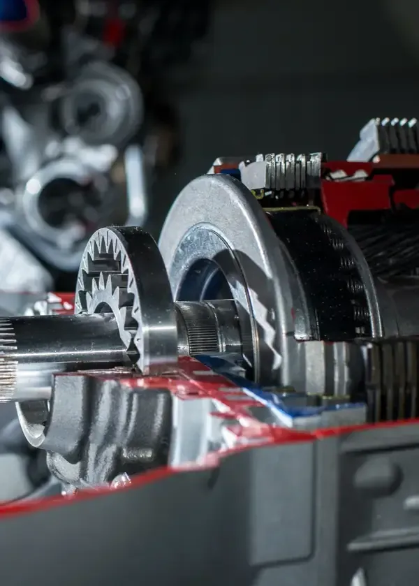 Close-up of metal gears and spinning components inside a machine, with red housing accents.