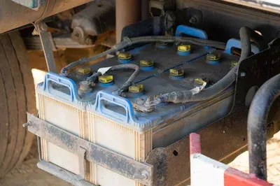 Dusty blue battery pack with yellow caps installed in a machine compartment