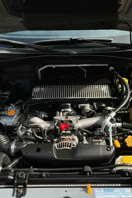 Open car engine bay with a large air intake and visible engine components
