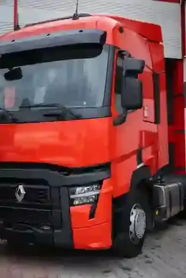 Red Renault semi-truck parked outside a warehouse