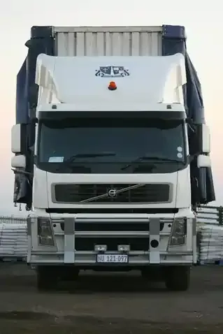 Front view of a white Volvo semi-truck parked outdoors.