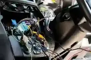 Messy car interior with exposed wires and dashboard components removed