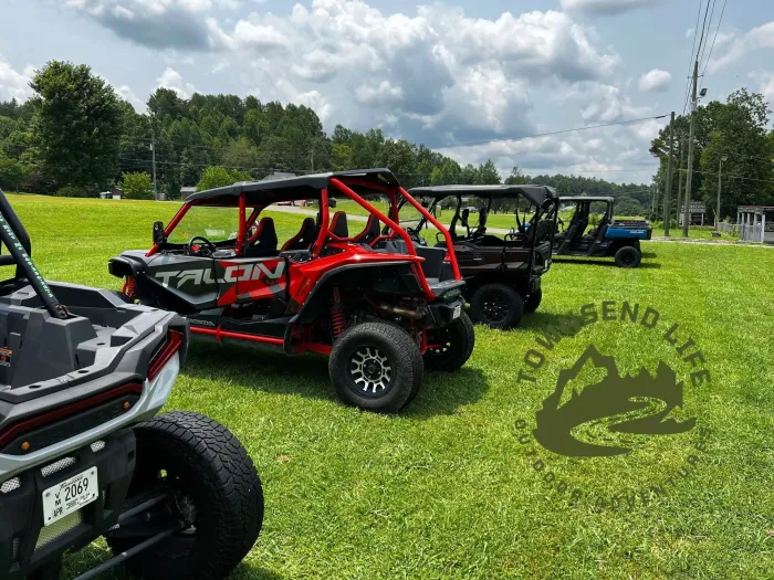 A row of atvs are parked in a grassy field.