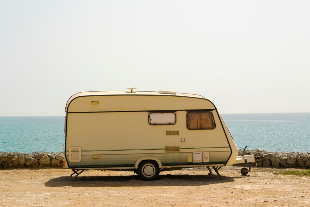 A Caravan Is Parked On The Beach Next To The Ocean — Total Auto Service In Caloundra West, QLD