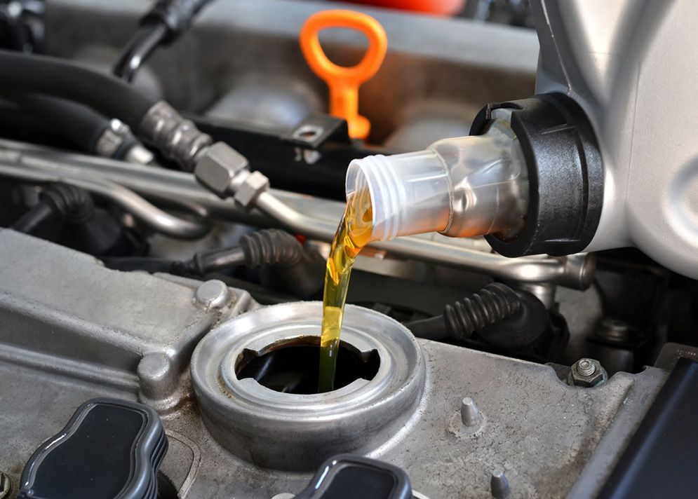 A Close Up Of A Person Pouring Oil Into A Car Engine — Total Auto Service In Caloundra West, QLD