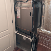 HVAC unit in a closet, with exposed ductwork and reflective insulation around the sides