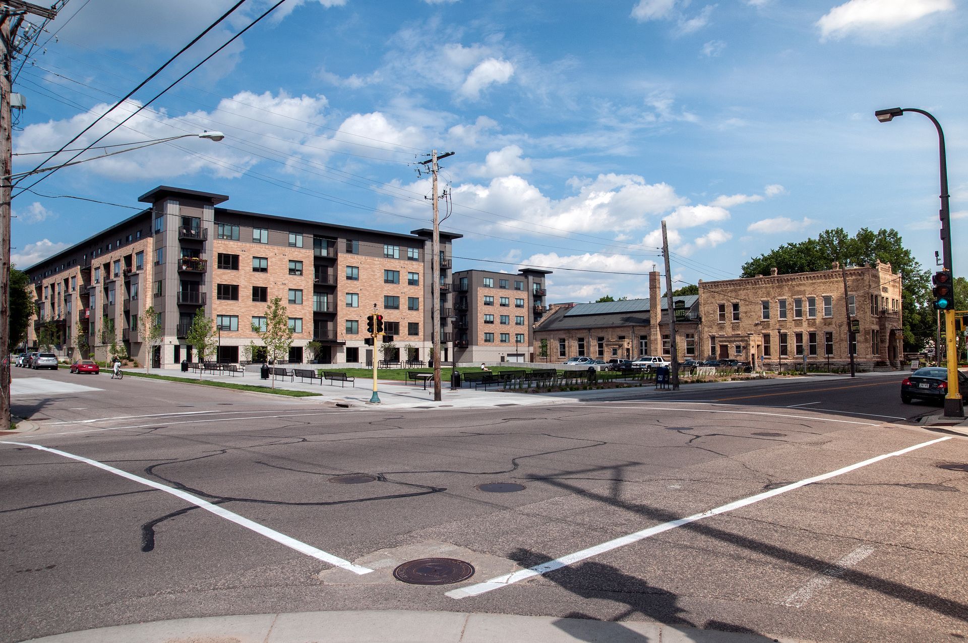 City intersection with brick buildings and blue sky.