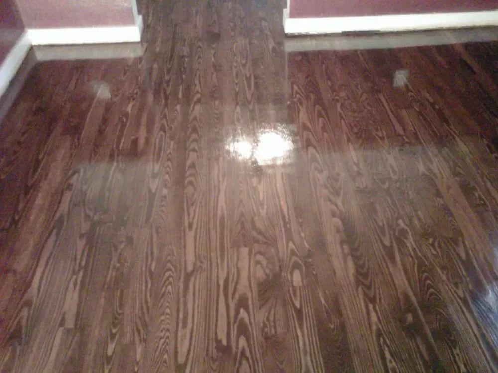 Shiny wooden floor with reflections in a hallway or room