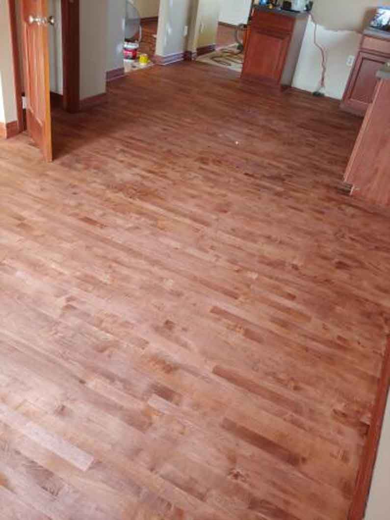 Wood-patterned flooring in an empty room with doorways and white walls