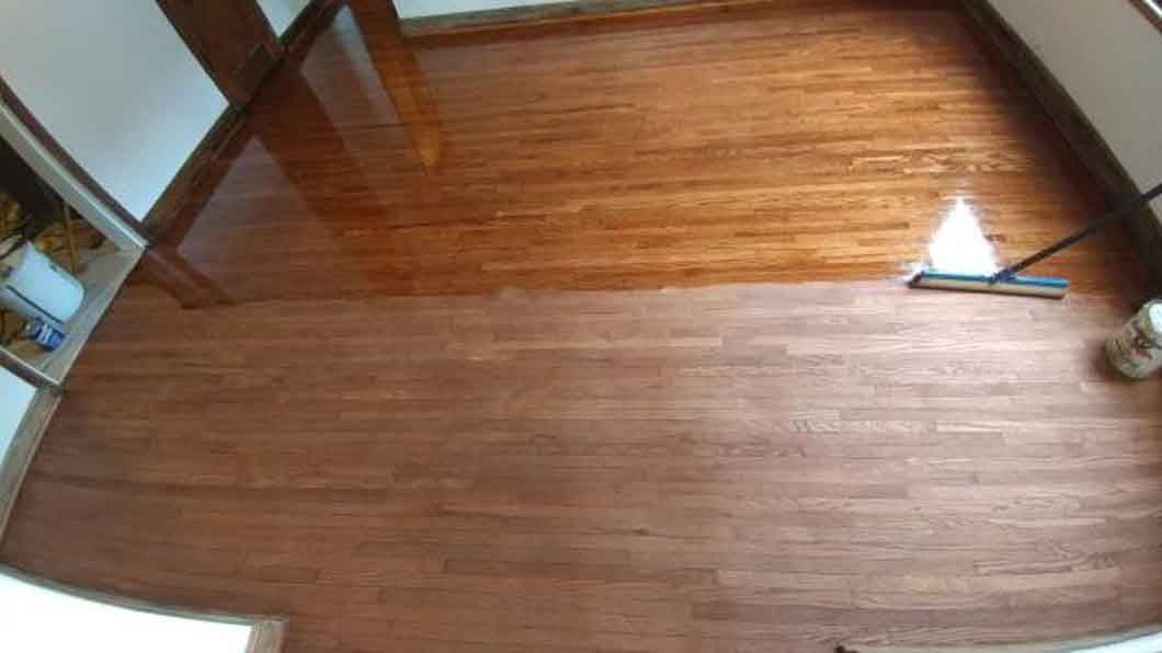 Empty hardwood-floored room with sunlight near a doorway and a small tool on the floor