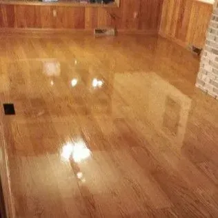 Empty polished wooden room with glossy floor reflections and wood-paneled walls