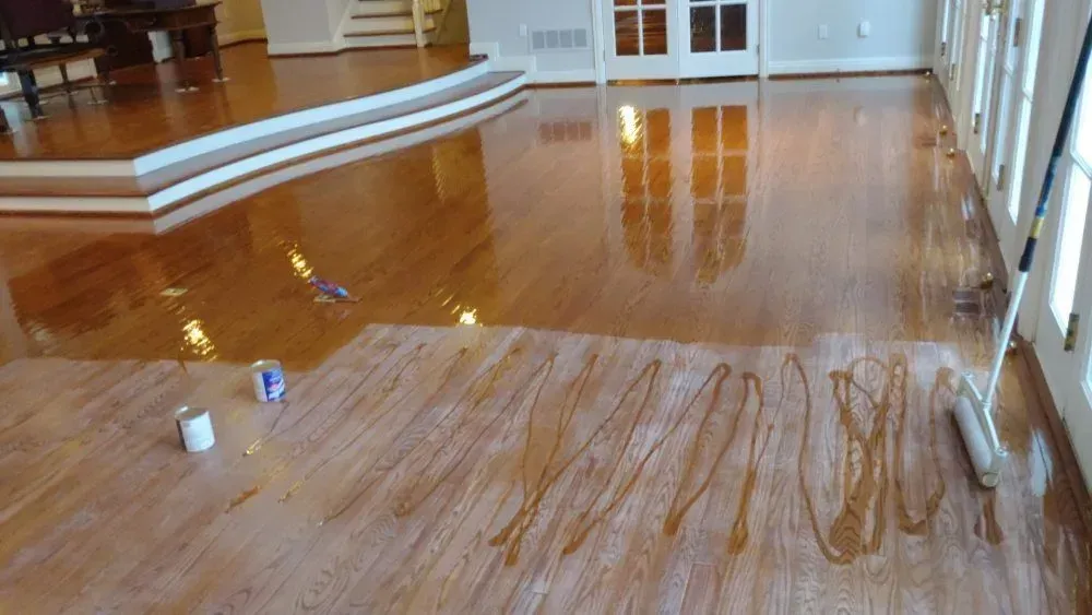 Empty polished floor with wet streaks and a few cleaning bottles in a hall or gymnasium