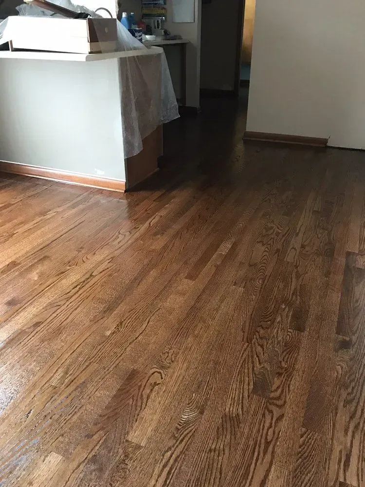 Empty room with wooden floor and a table covered by a white cloth in the corner