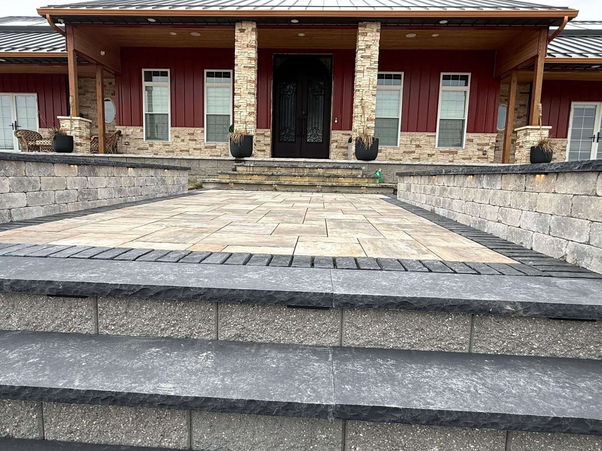 Stone walkway leading to a brick house with front steps, columns, and a covered porch