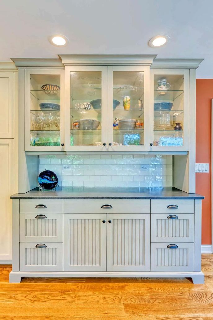 A white cabinet with glass doors and drawers in a kitchen.