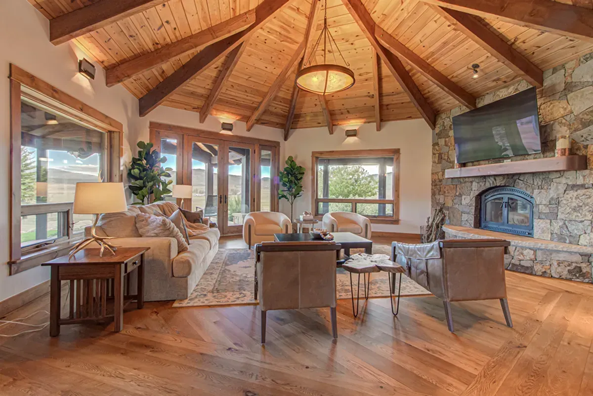 A living room with a wooden ceiling and a fireplace.