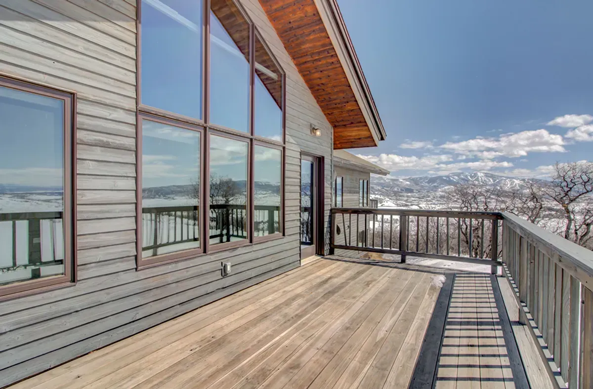 A large deck with a railing and a view of a mountain.
